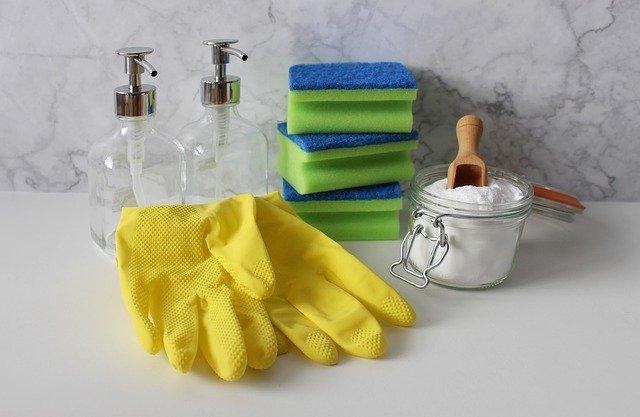 Cleaning gloves next to sponges and cleaning soap.