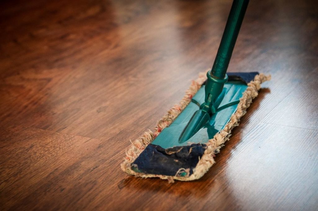 A mop over a brown wooden floor